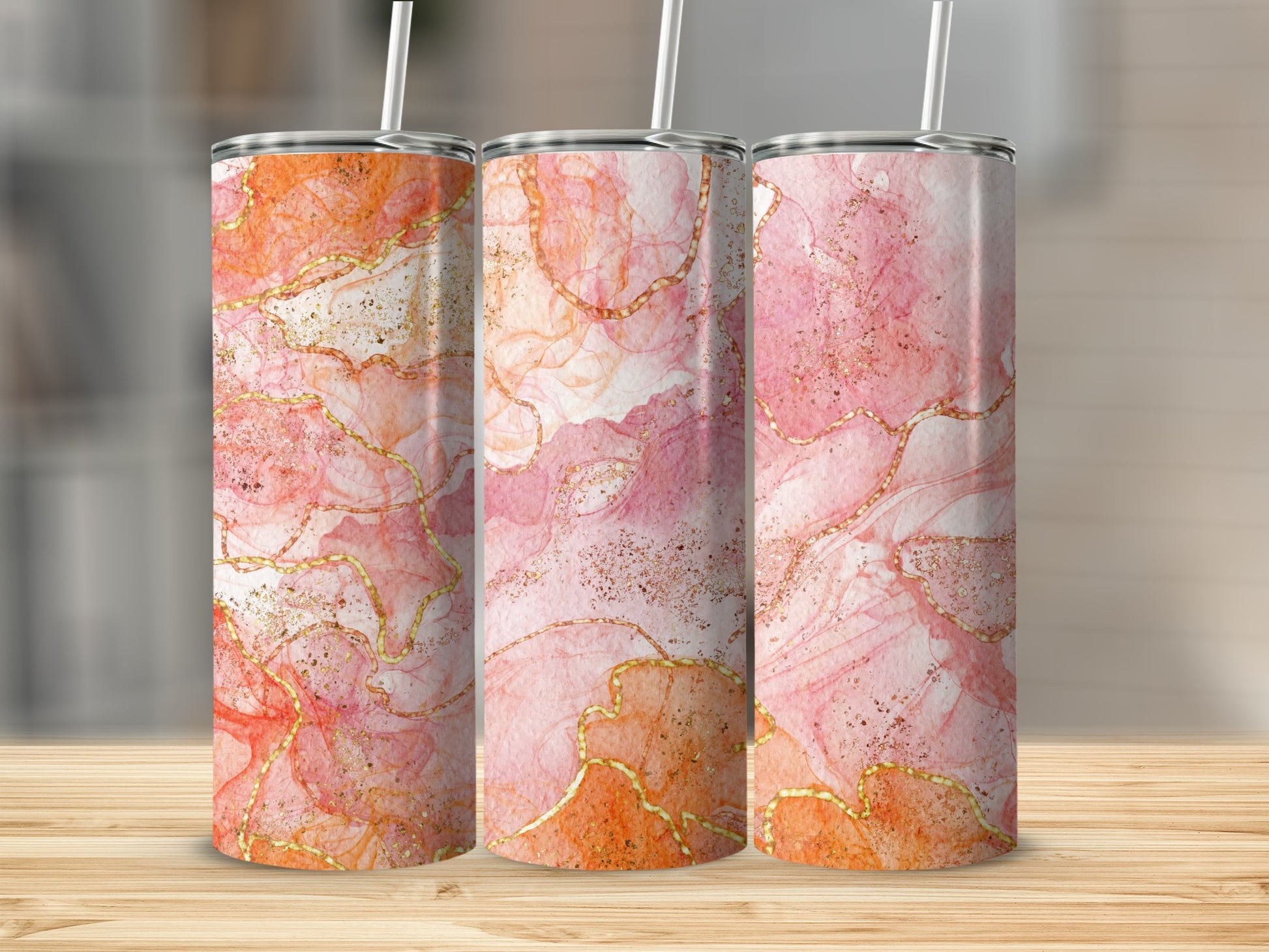 Three tumblers with pink and orange marbled design and gold accents.