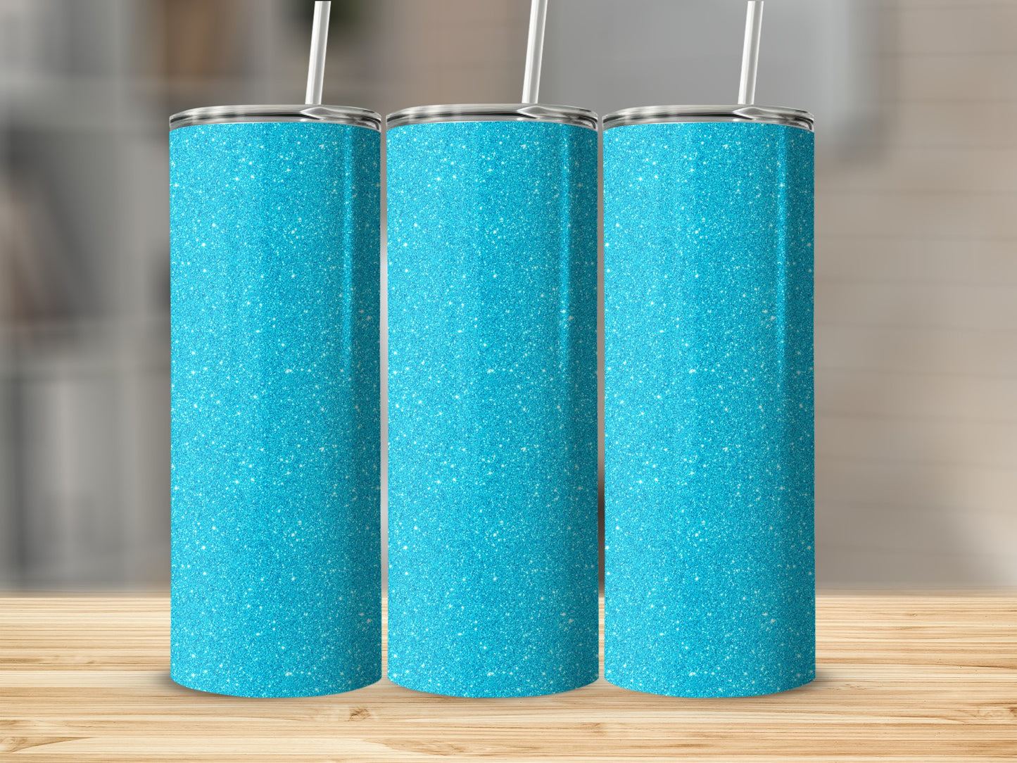 Three turquoise glitter tumblers with straws displayed on a wooden surface.