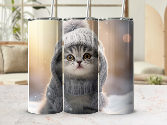 Gray kitten wearing a knitted hat and sweater, with bokeh background.