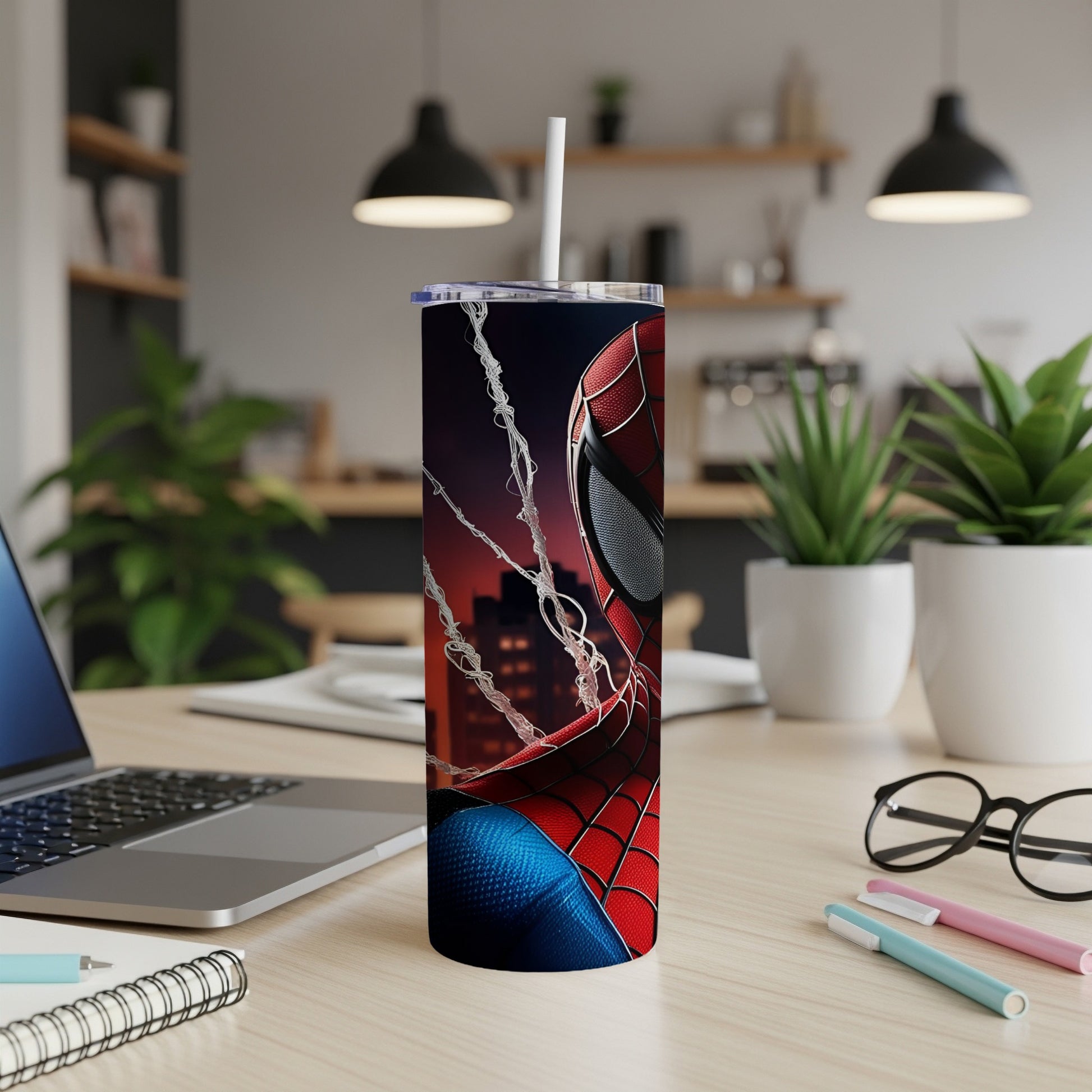Spiderman tumbler with city skyline and webs on a desk.