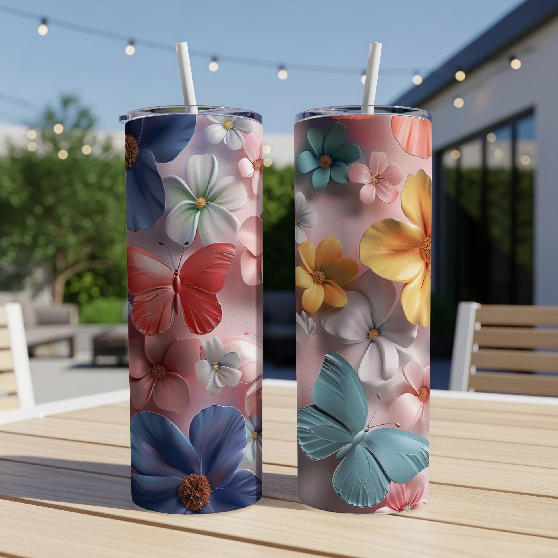 Two floral tumblers with butterflies on a wooden table outdoors.