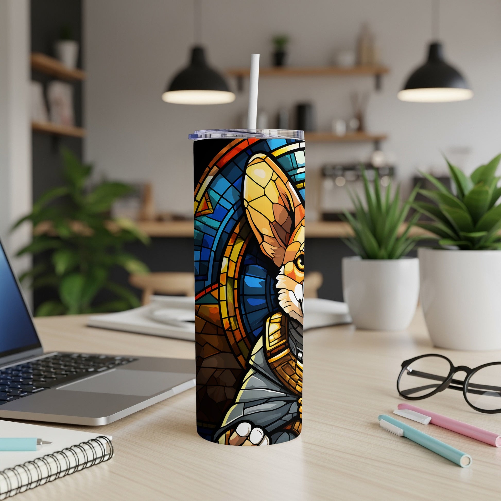 Tumbler with stained glass fox design and white straw on a desk.