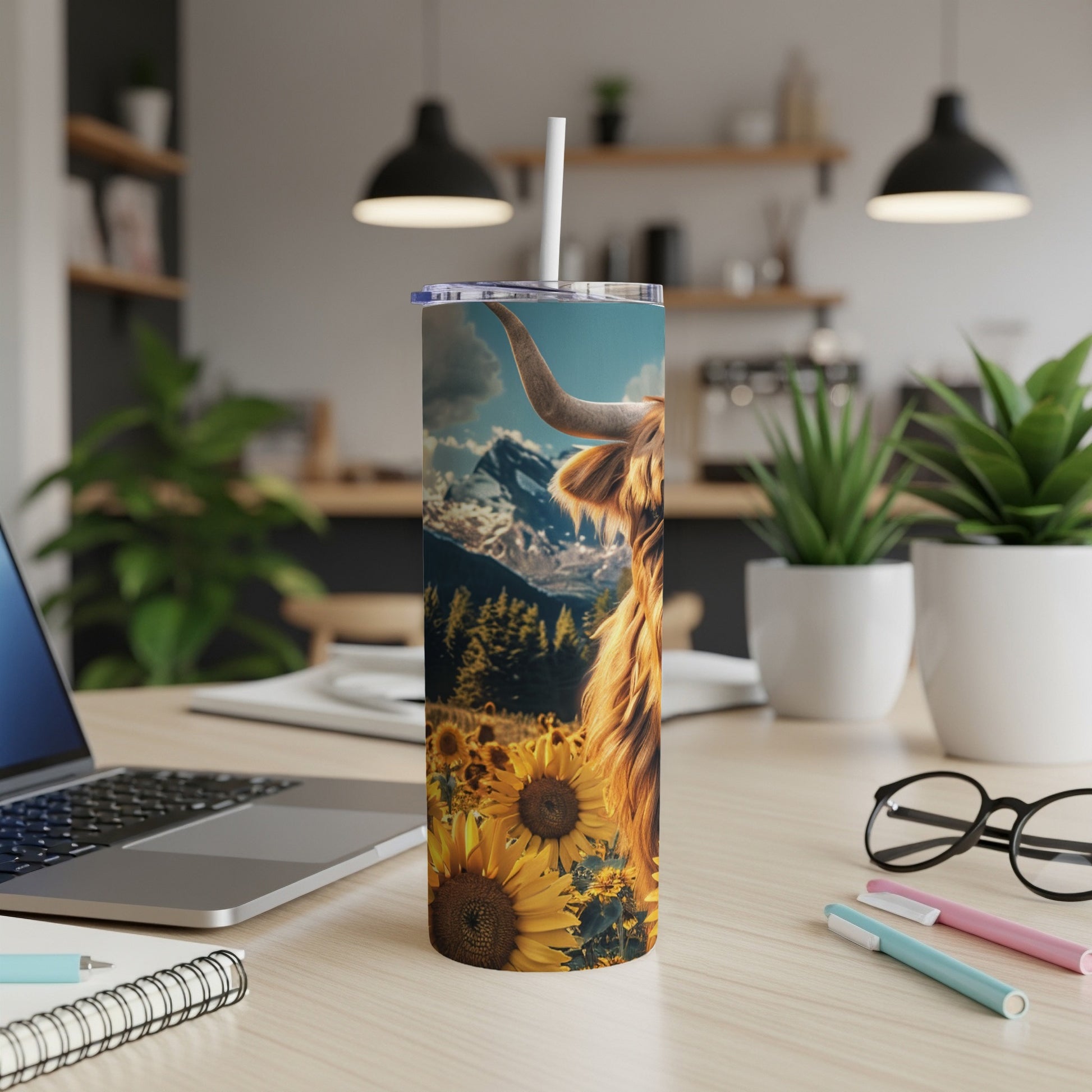 Highland cow in sunflower field with mountains, on a tumbler.