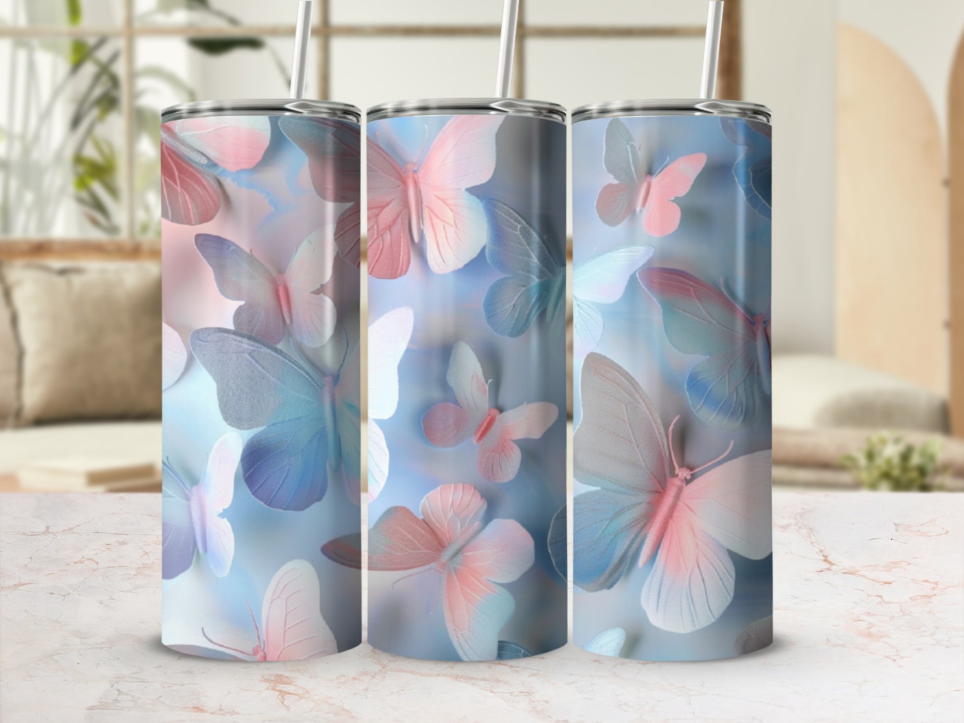 Three tumblers with a pastel butterfly design and straws.