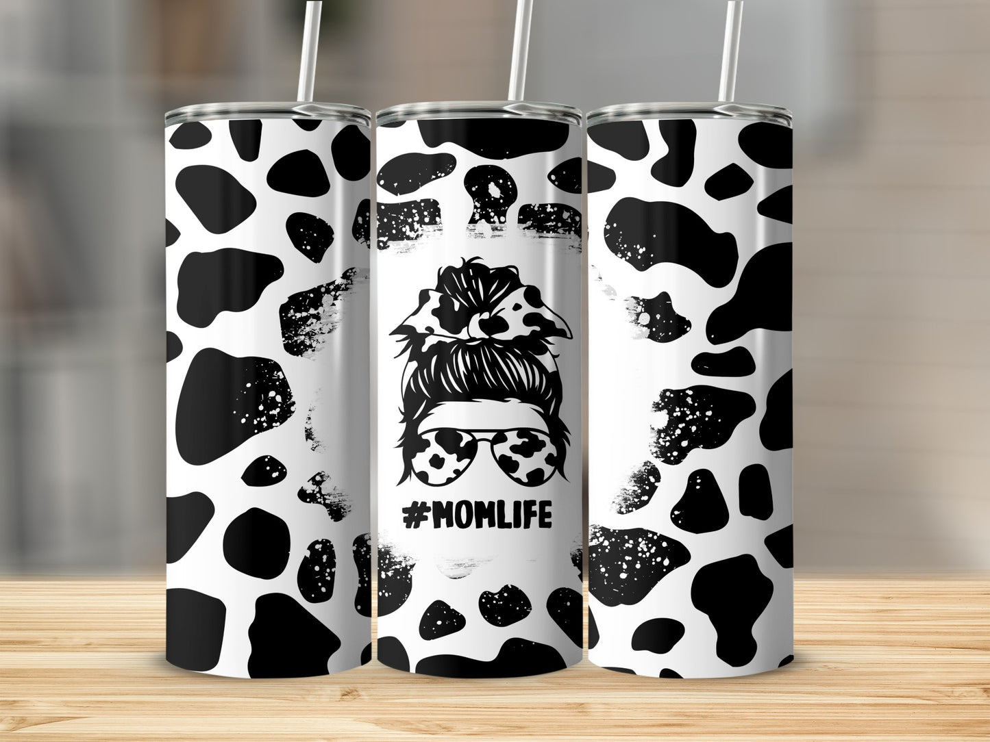 Tumbler with cow print pattern and "#MOMLIFE" graphic.