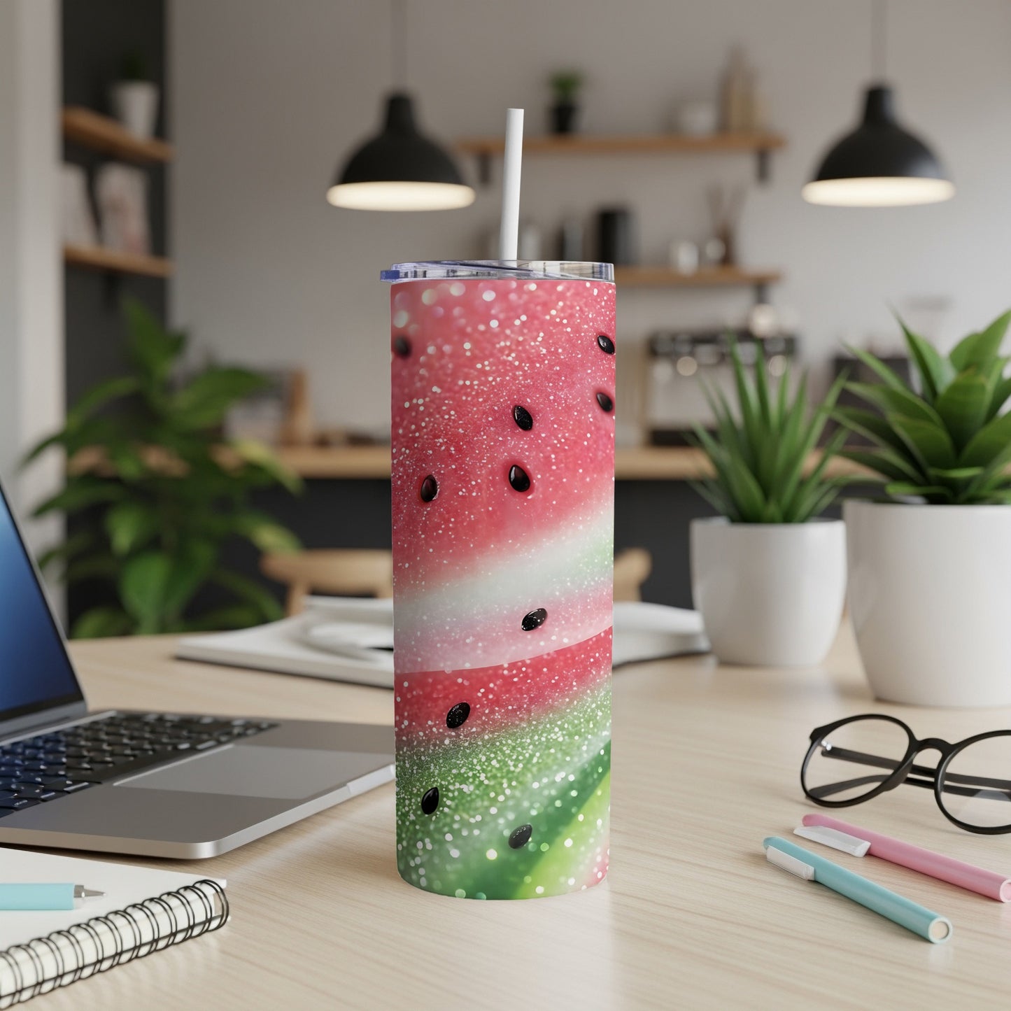 Tumbler with watermelon design and white straw on a desk.