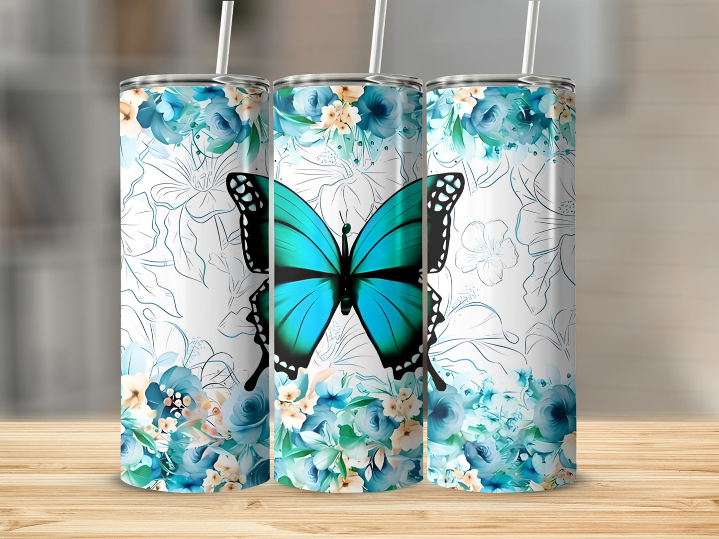 Blue butterfly and floral pattern on three white stainless steel tumblers.