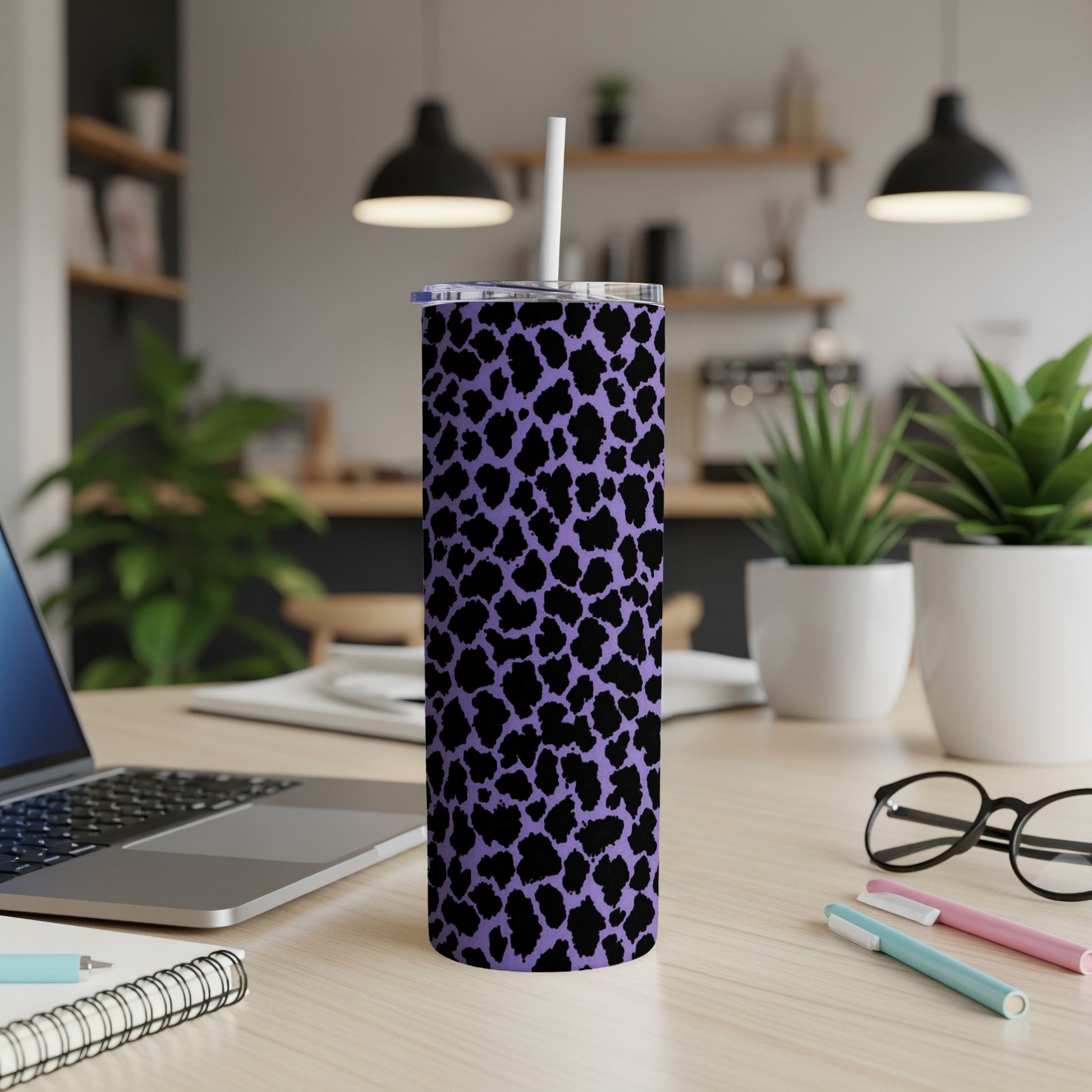 Purple tumbler with black leopard print, on a desk with a laptop and plants.