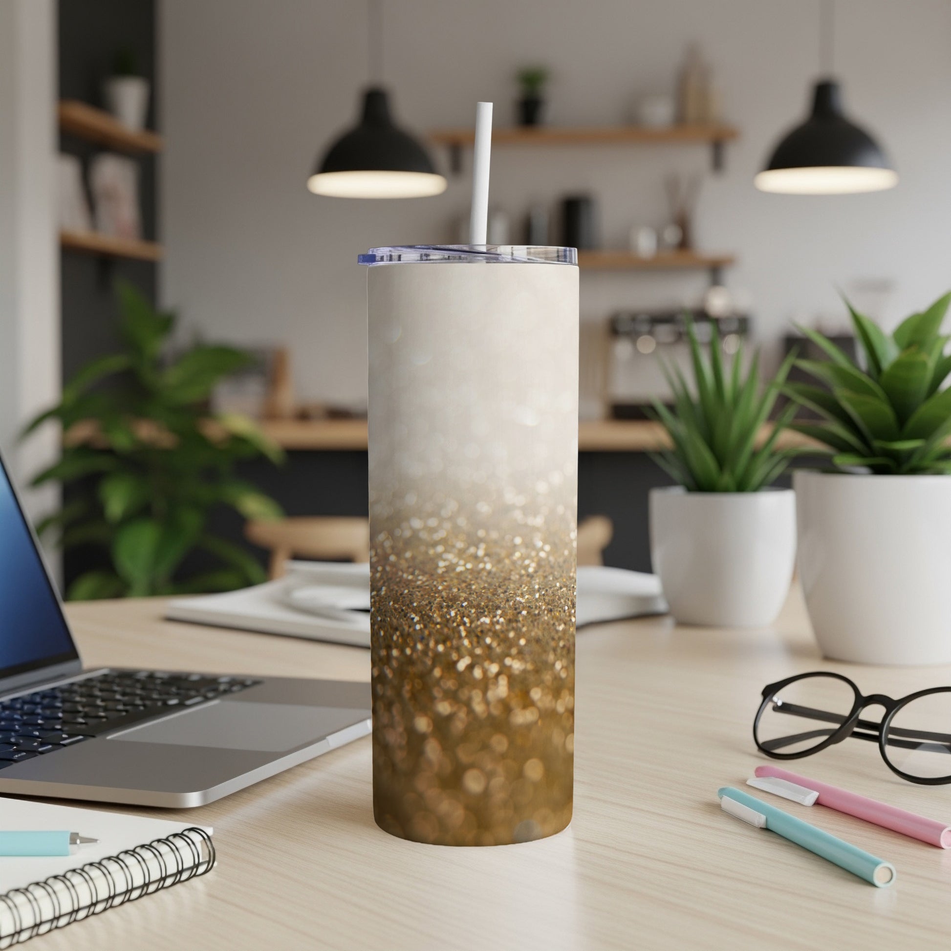 Glitter ombre tumbler with white lid and straw on desk.