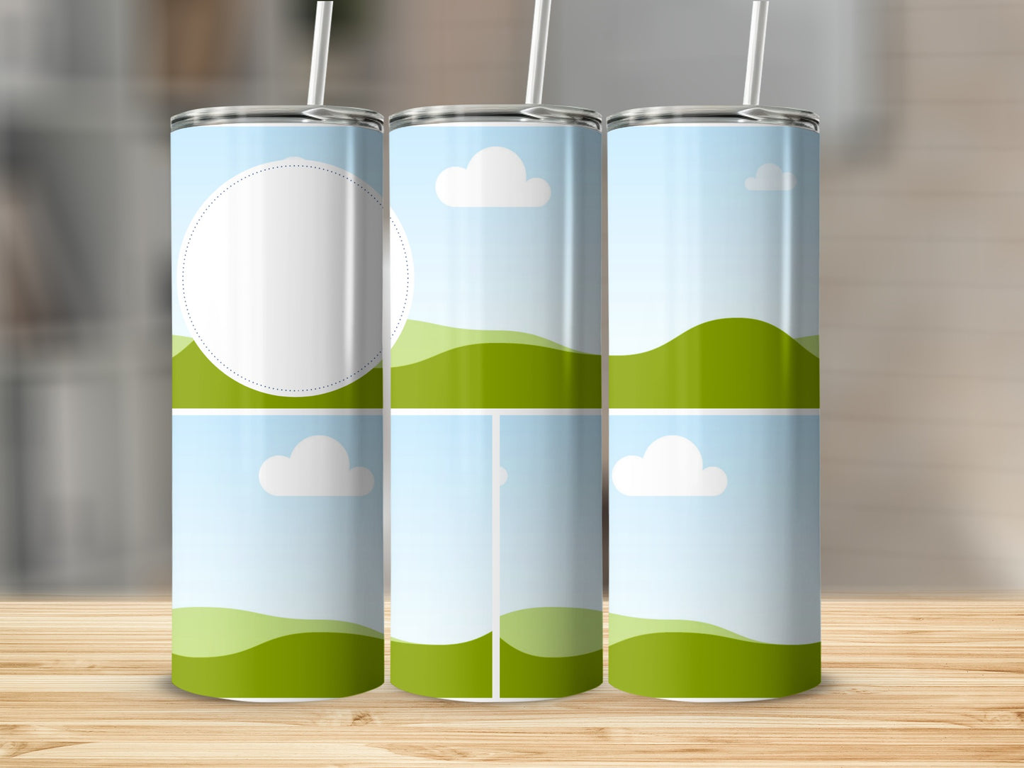 Three tumblers with landscape design featuring clouds and green hills.
