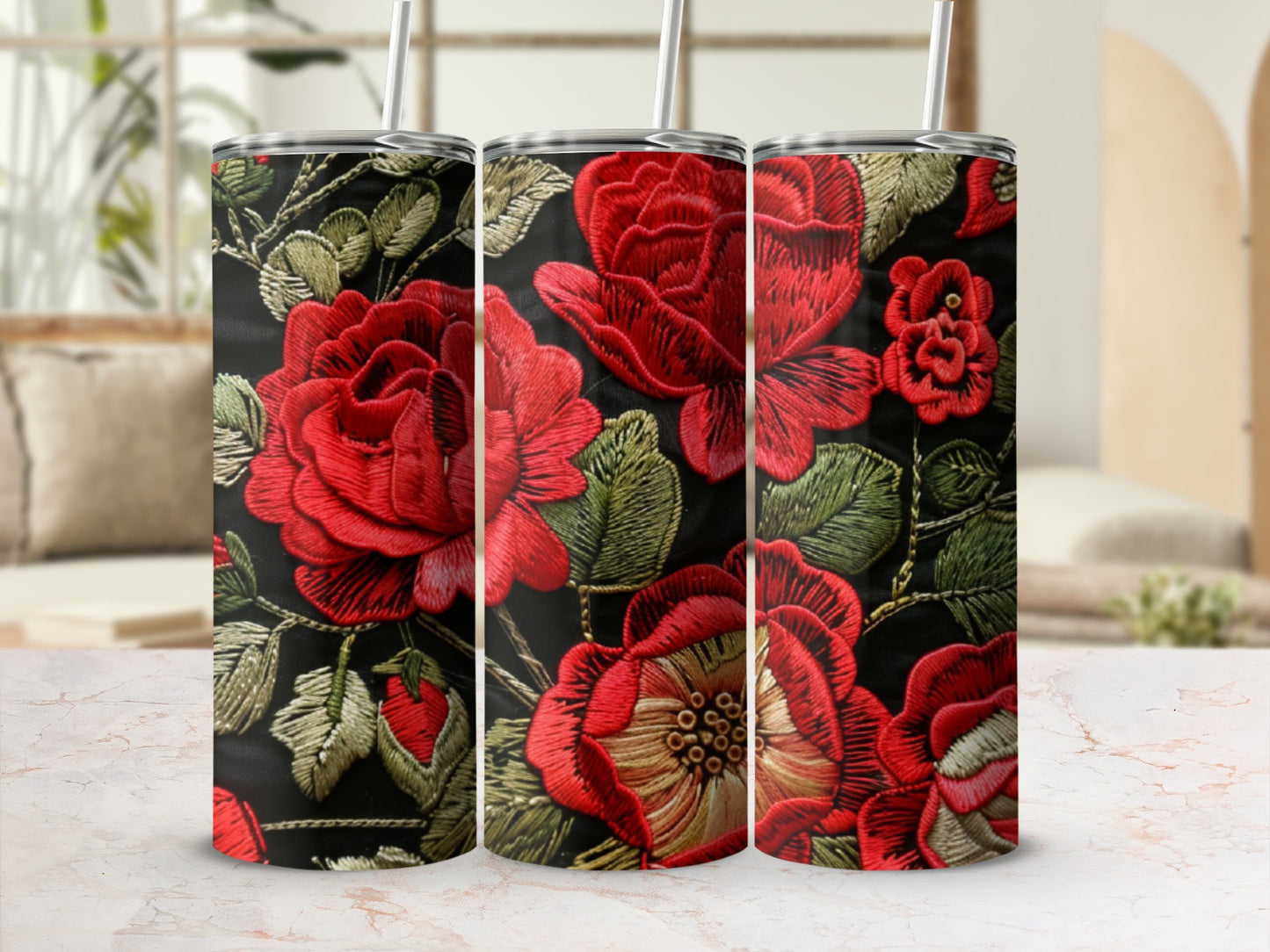 Black tumbler with detailed red floral embroidery and straw.