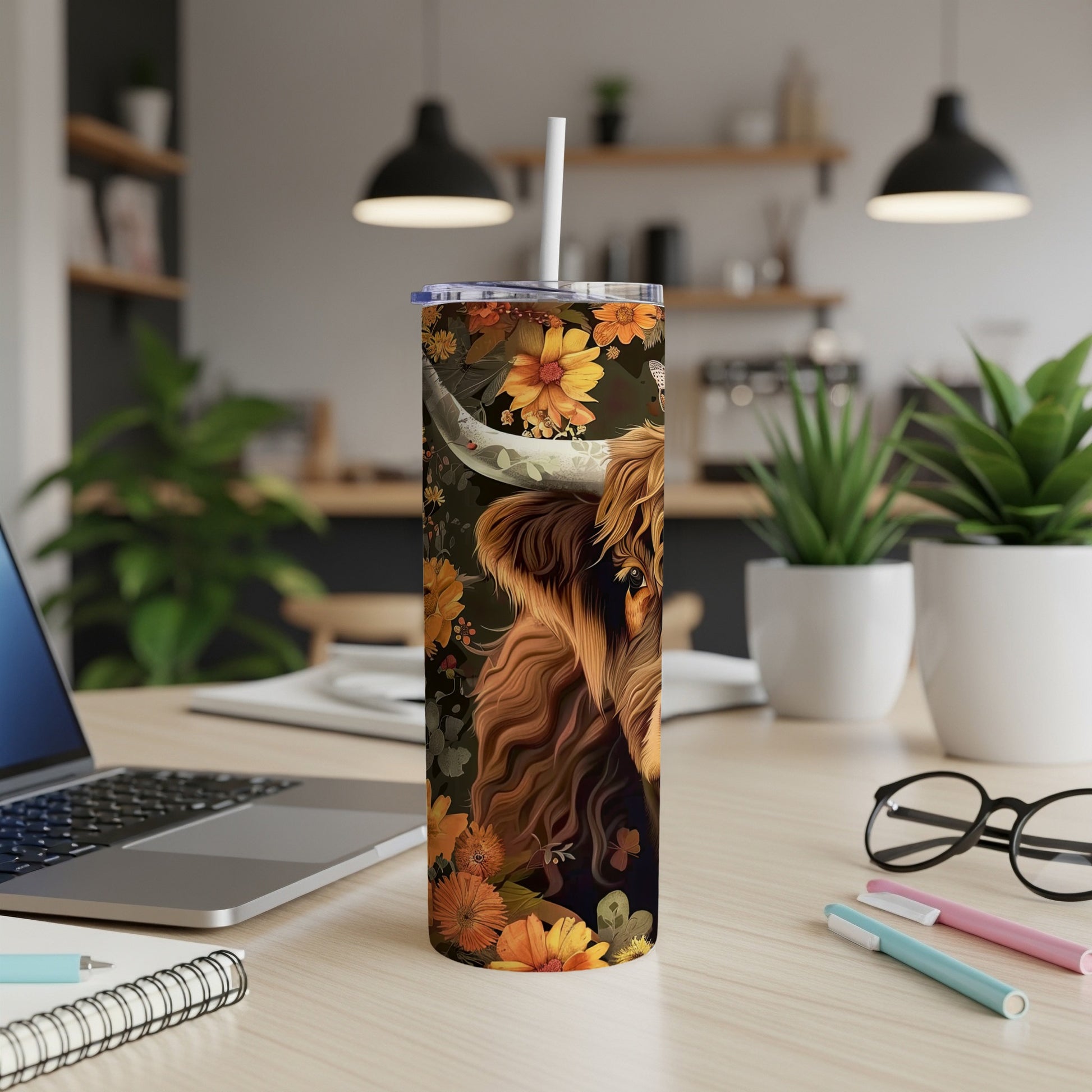 Highland cow with floral accents on a white skinny tumbler with straw.