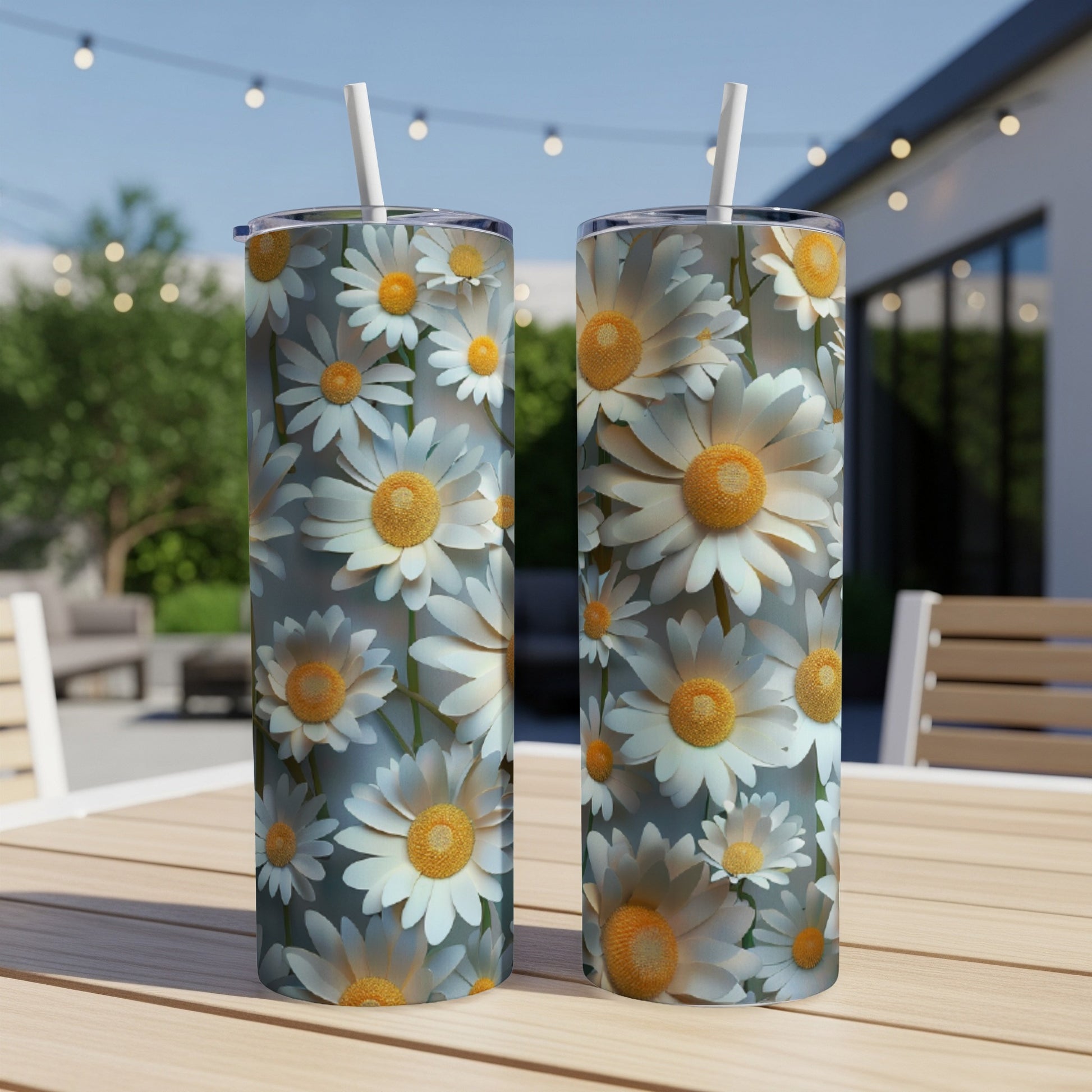 White and yellow daisies cover this pair of white travel tumblers with straws.