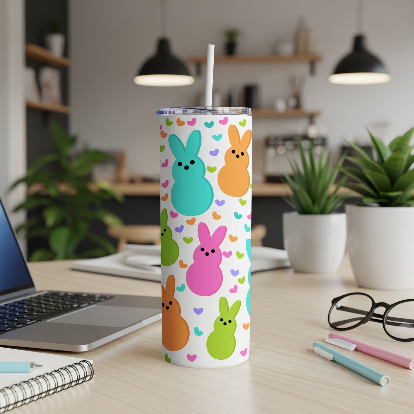 White tumbler with colorful bunny and heart pattern, straw in lid.