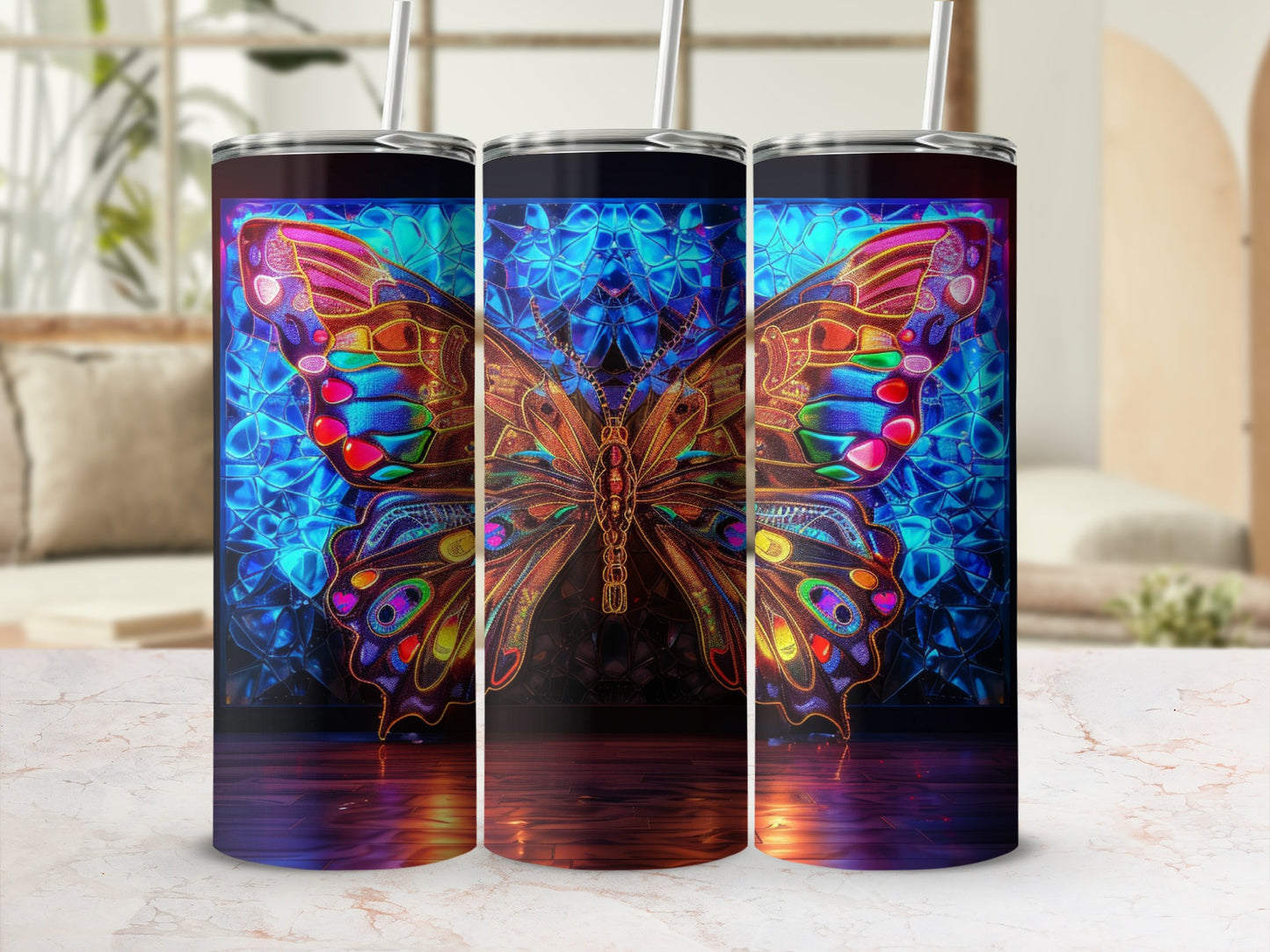 Three tumblers featuring a colorful, ornate butterfly against a blue geometric background.