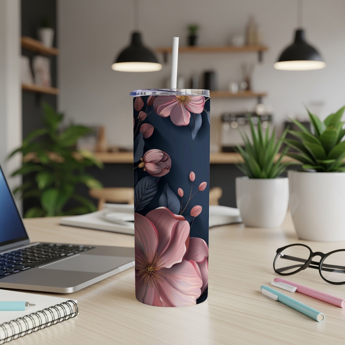Dark blue tumbler with pink floral design on desk.