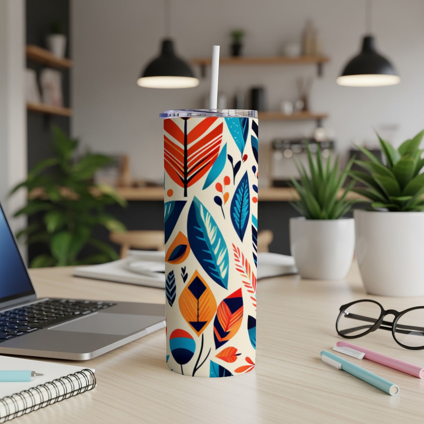 Colorful abstract floral pattern on a tall, insulated tumbler with a straw.