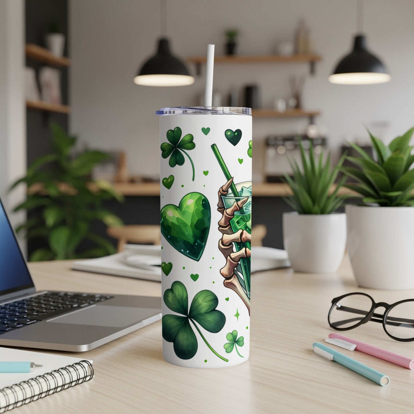 White tumbler with green shamrocks and a skeleton hand holding a drink.
