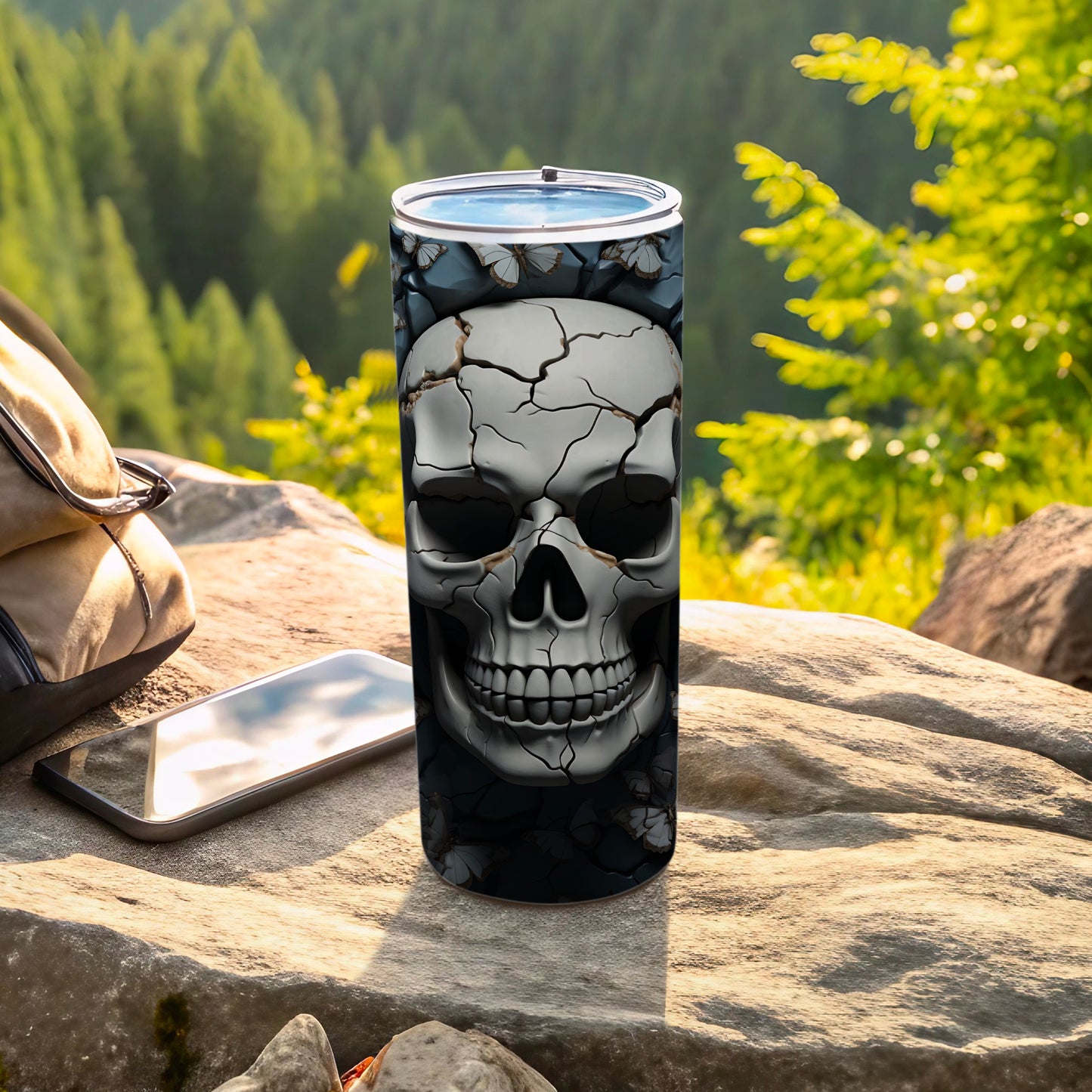 Cracked skull design on a tumbler with phone and backpack.