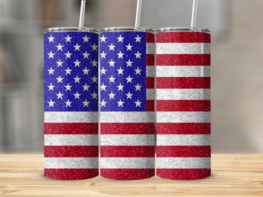 Three tumblers with glittery American flag design on a wooden surface.