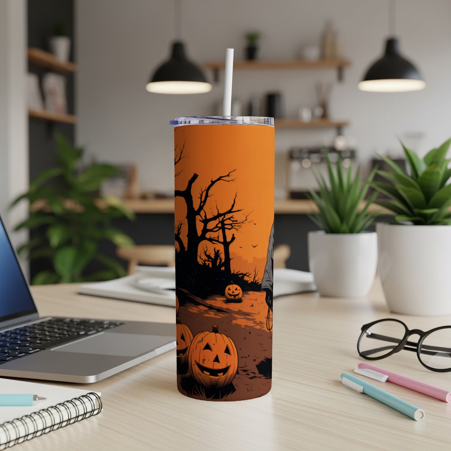 Tall tumbler with Halloween design featuring jack-o'-lanterns and silhouetted trees on an orange background.