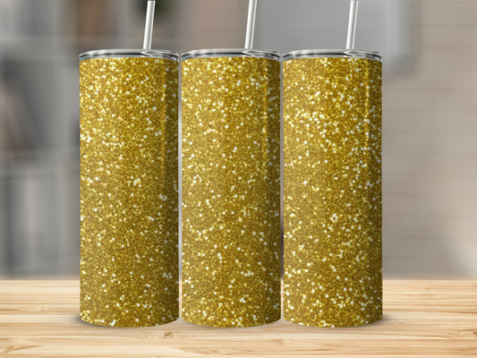 Three gold glitter tumblers with straws on a wooden surface.