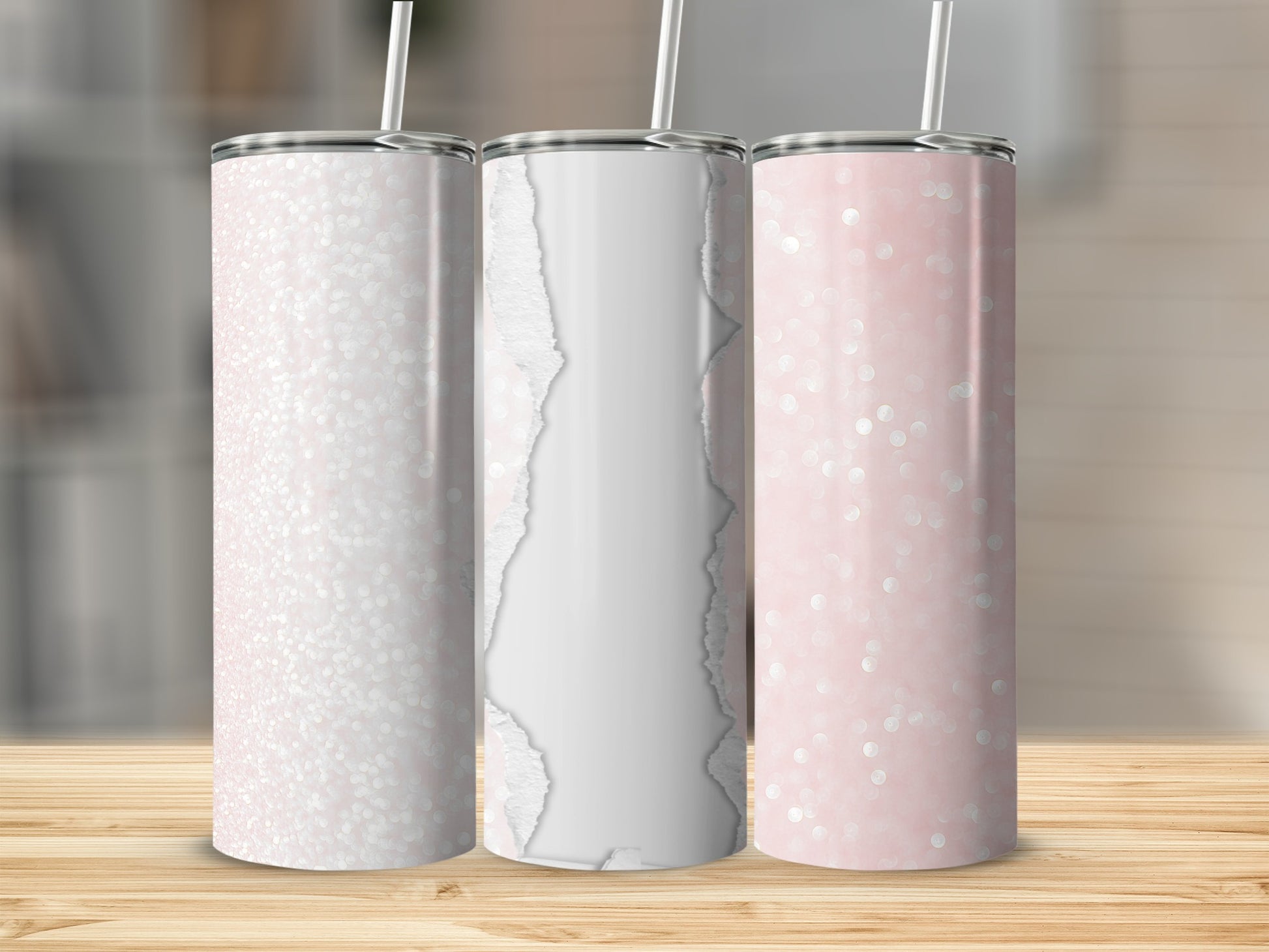 Three pink glitter tumblers with straws on a wooden surface.