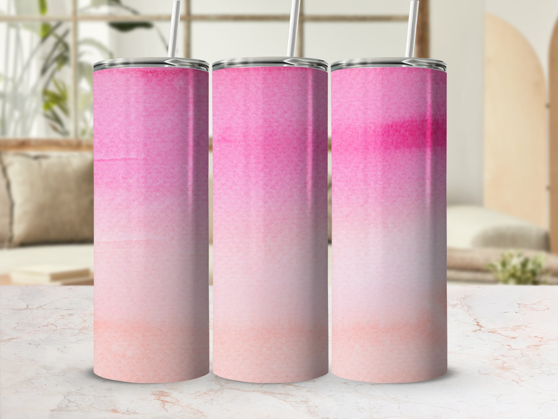 Three pink and orange watercolor gradient tumblers with straws.