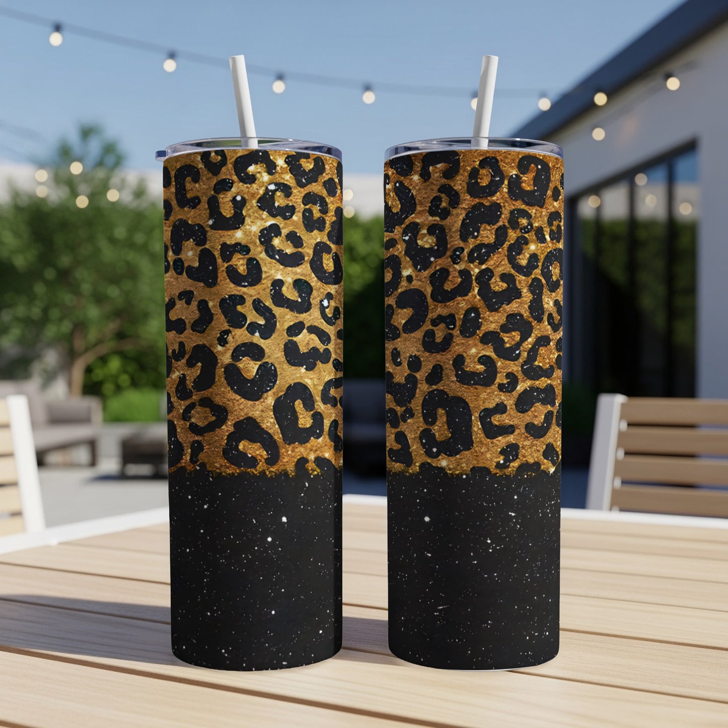 Two tall, gold leopard print tumblers with black glitter base and straws.