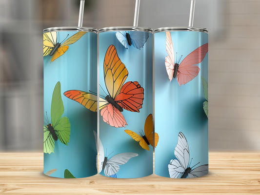 Three colorful butterfly tumblers on a wooden surface against a blue background.