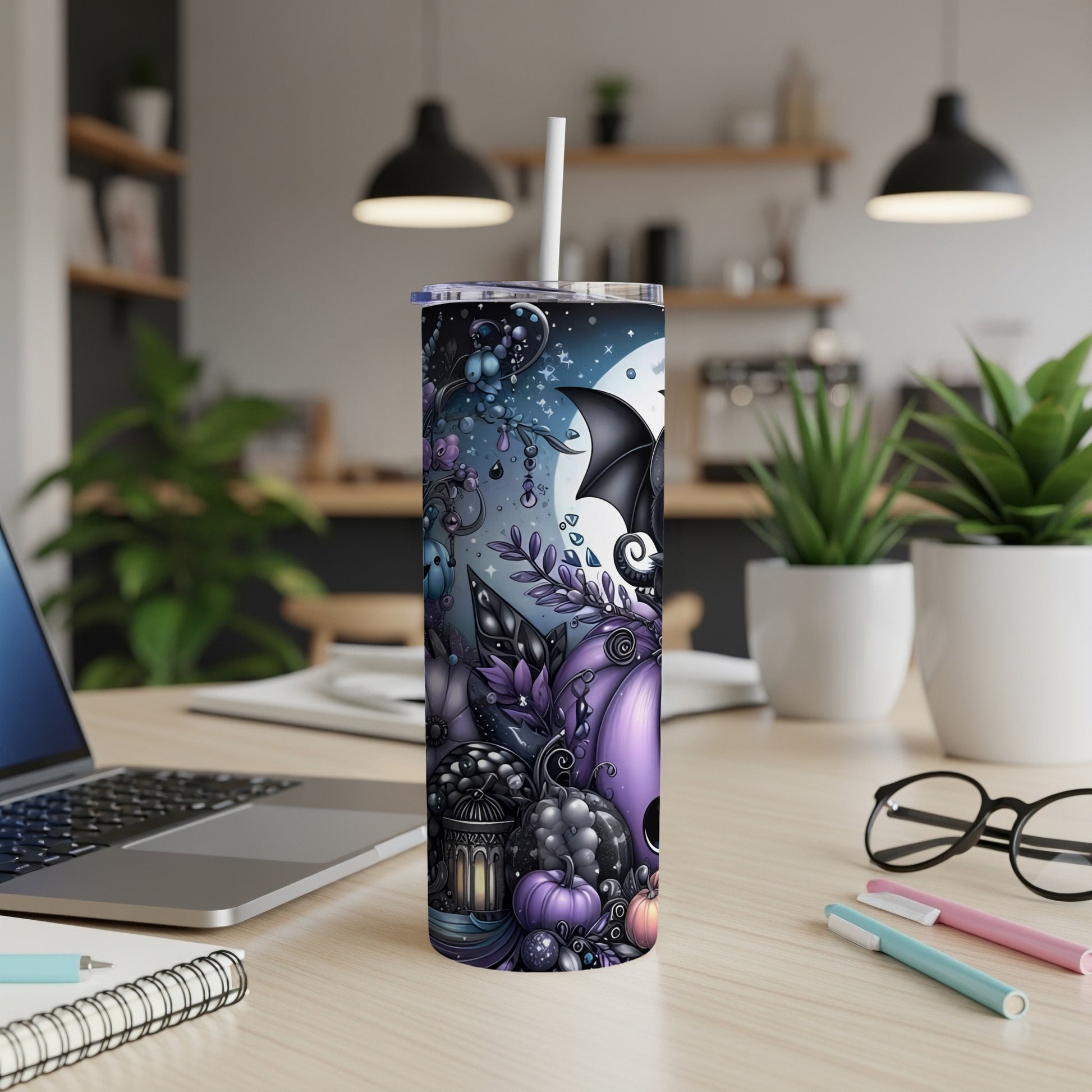 Halloween themed tumbler with bats, pumpkins, and moon on a table.