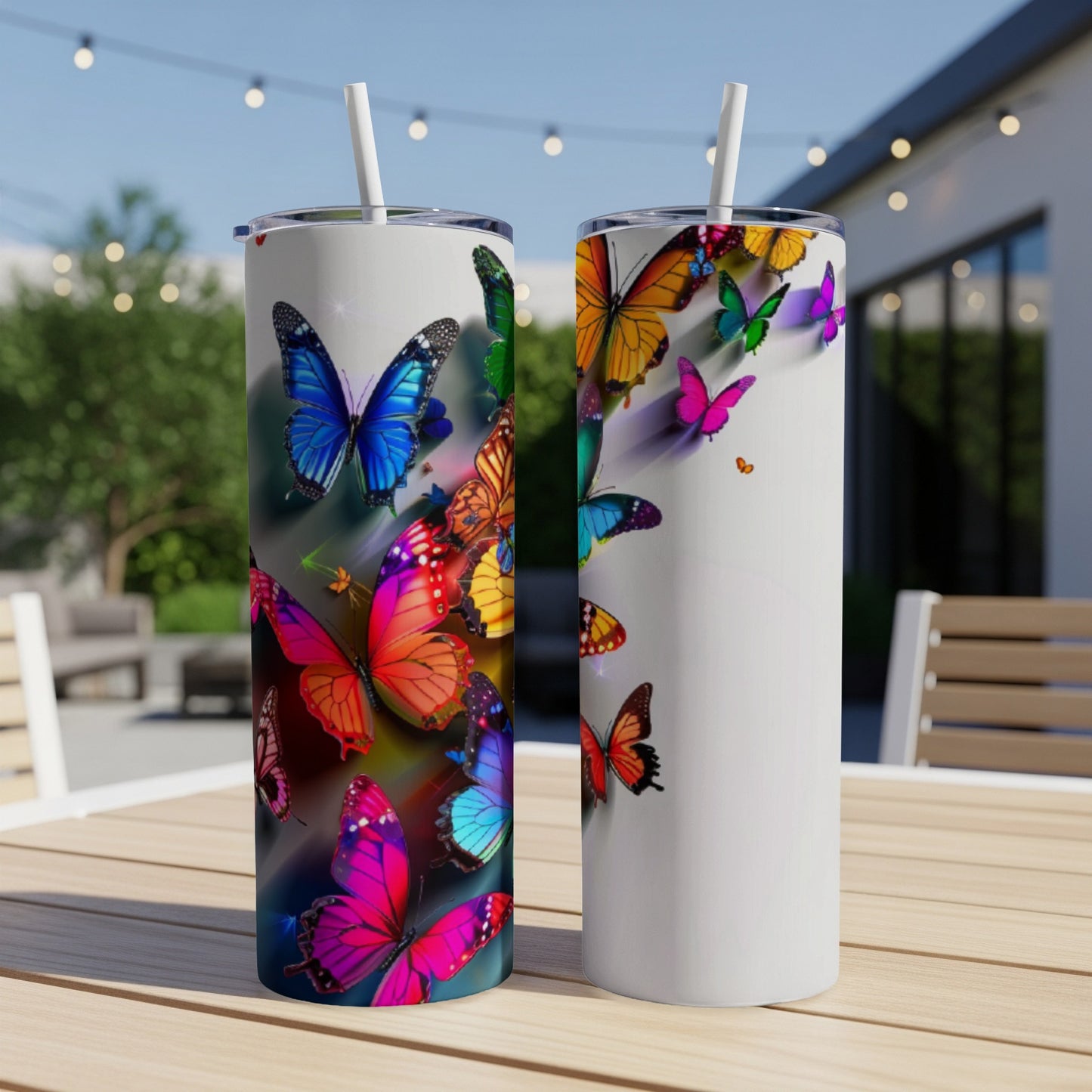 Two tall tumblers adorned with colorful butterfly designs on a wooden table.