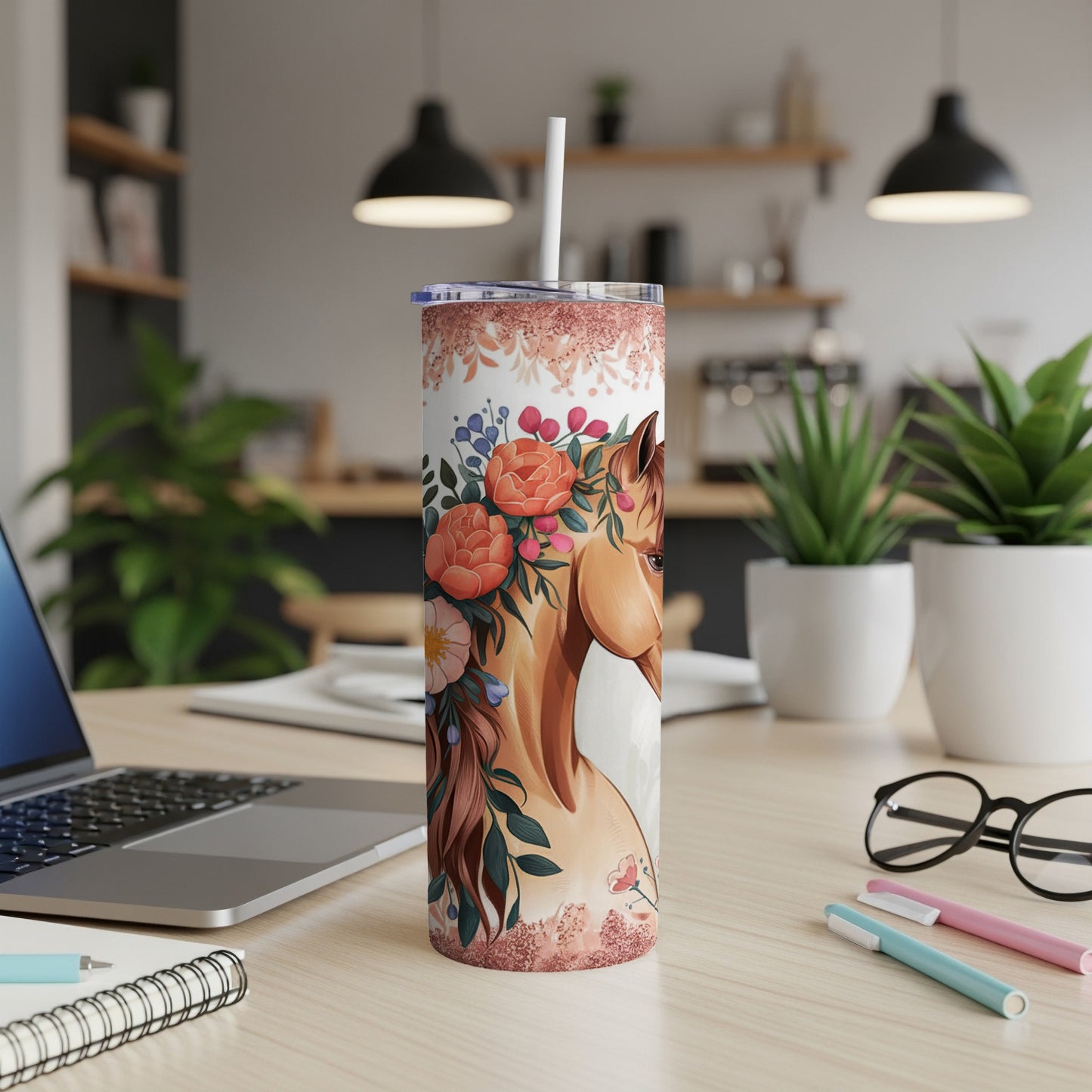 Tumbler with a horse and floral design, resting on a desk.