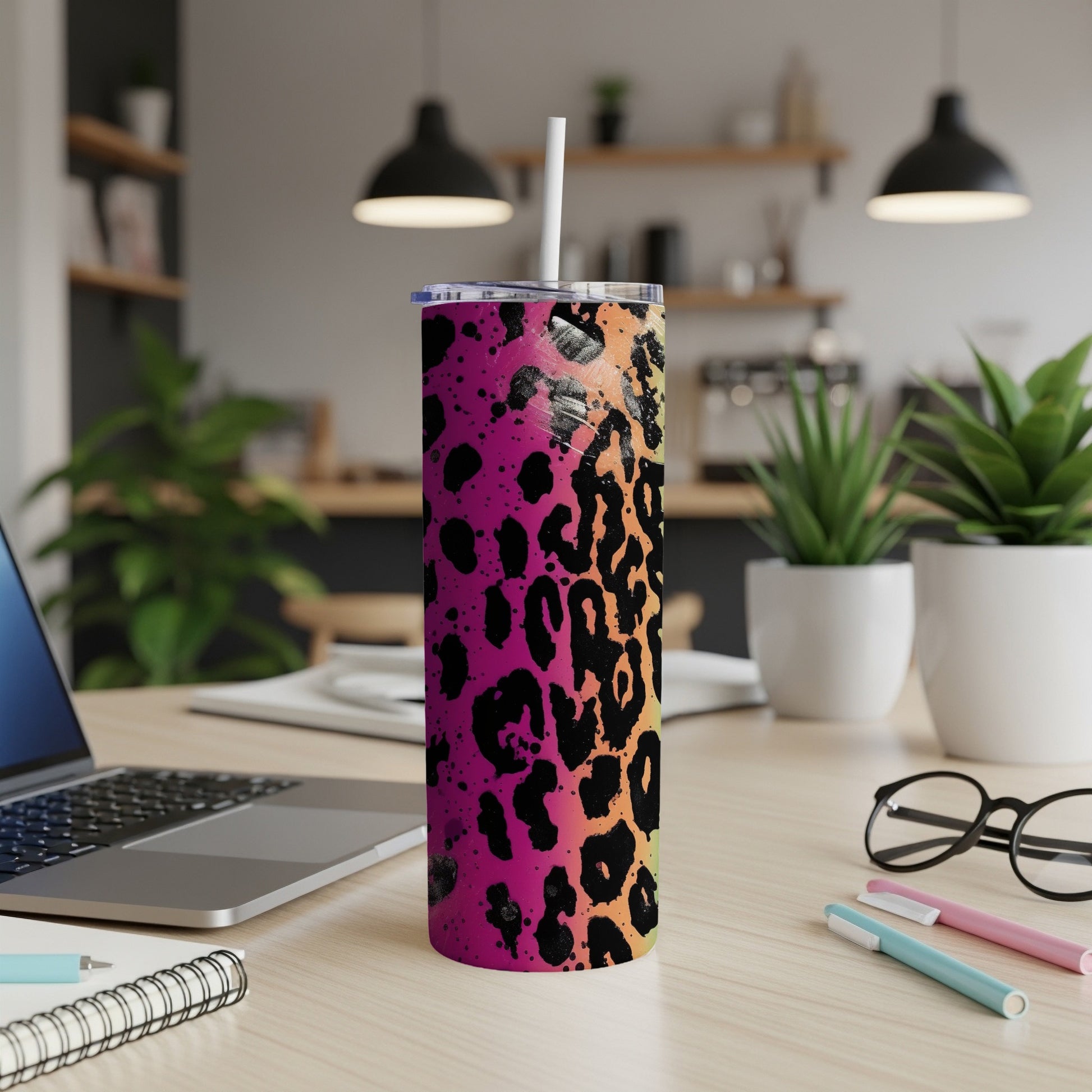 Leopard print tumbler with a pink and orange gradient, on a desk with a laptop.