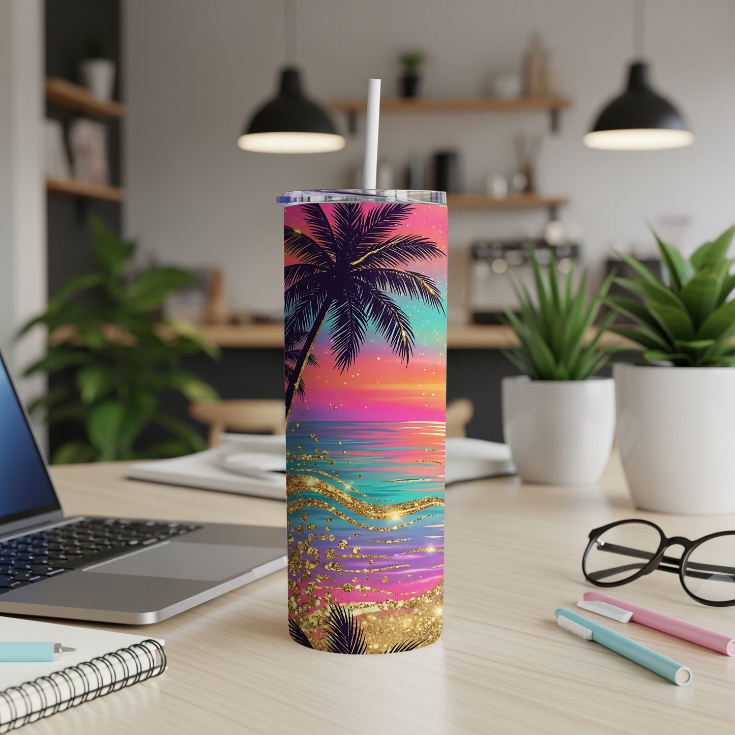 Colorful sunset palm tree tumbler with glitter accents on a desk.