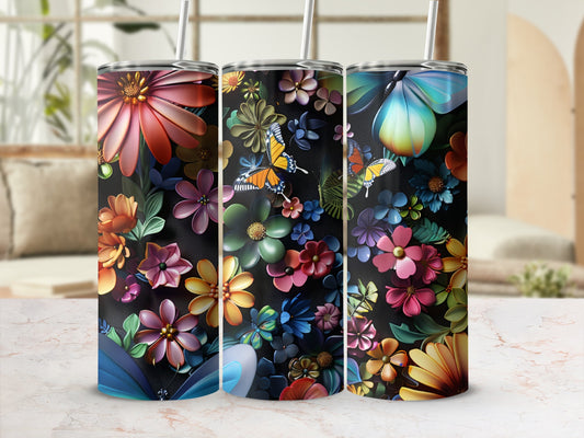 Three tumblers with colorful floral and butterfly designs on a marble surface.