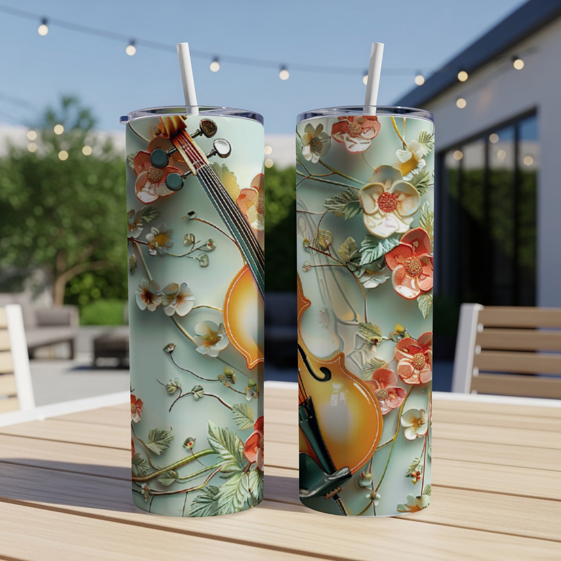 Two tall tumblers with floral violin designs sit on a table.