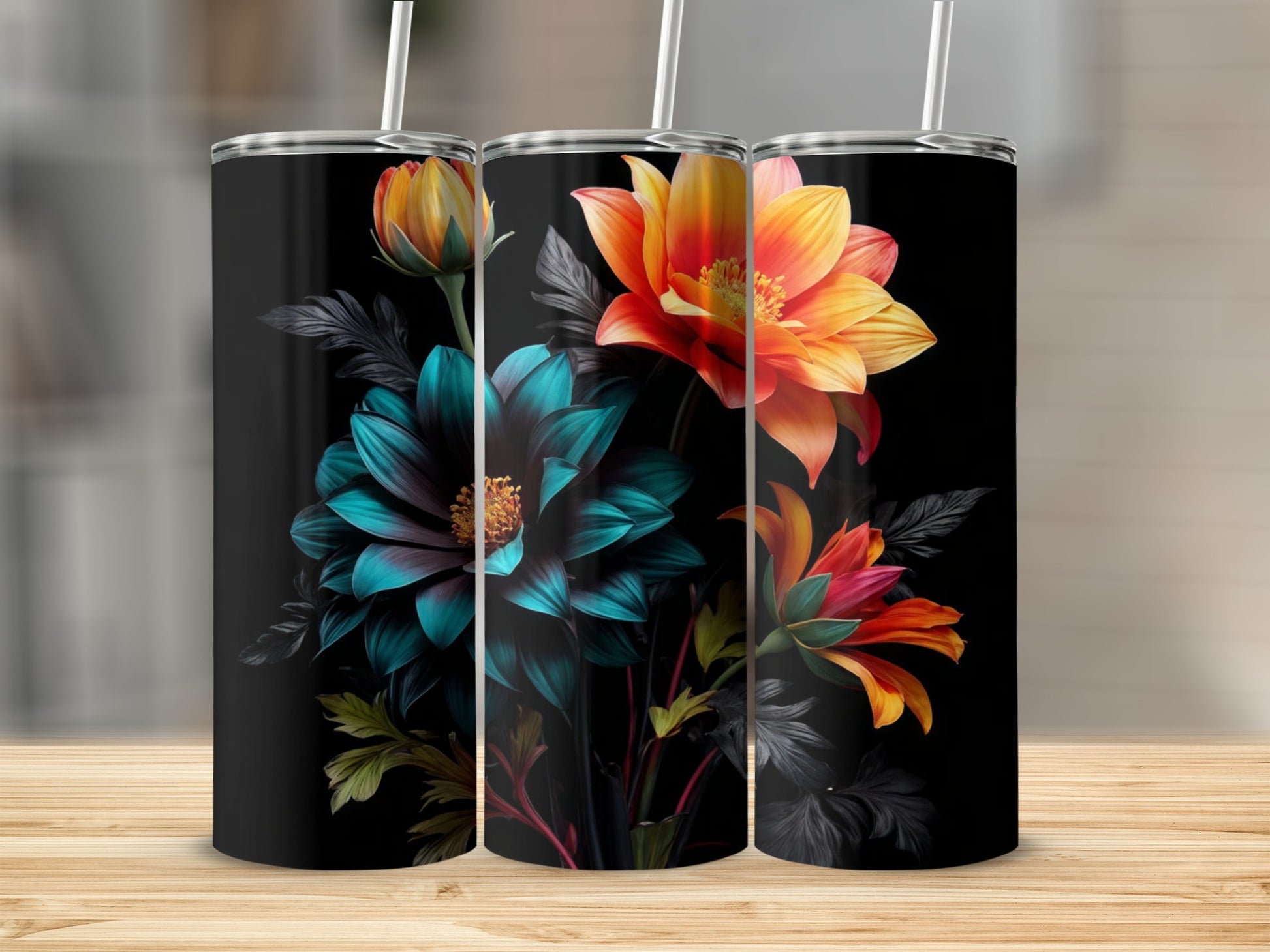 Three black tumblers with floral designs, two showing orange and yellow flowers, one with blue and green.