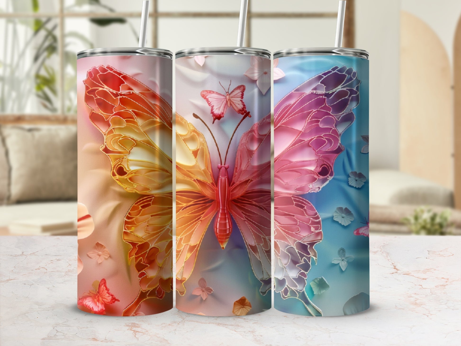 Three tumblers with colorful butterfly designs in warm and cool tones.