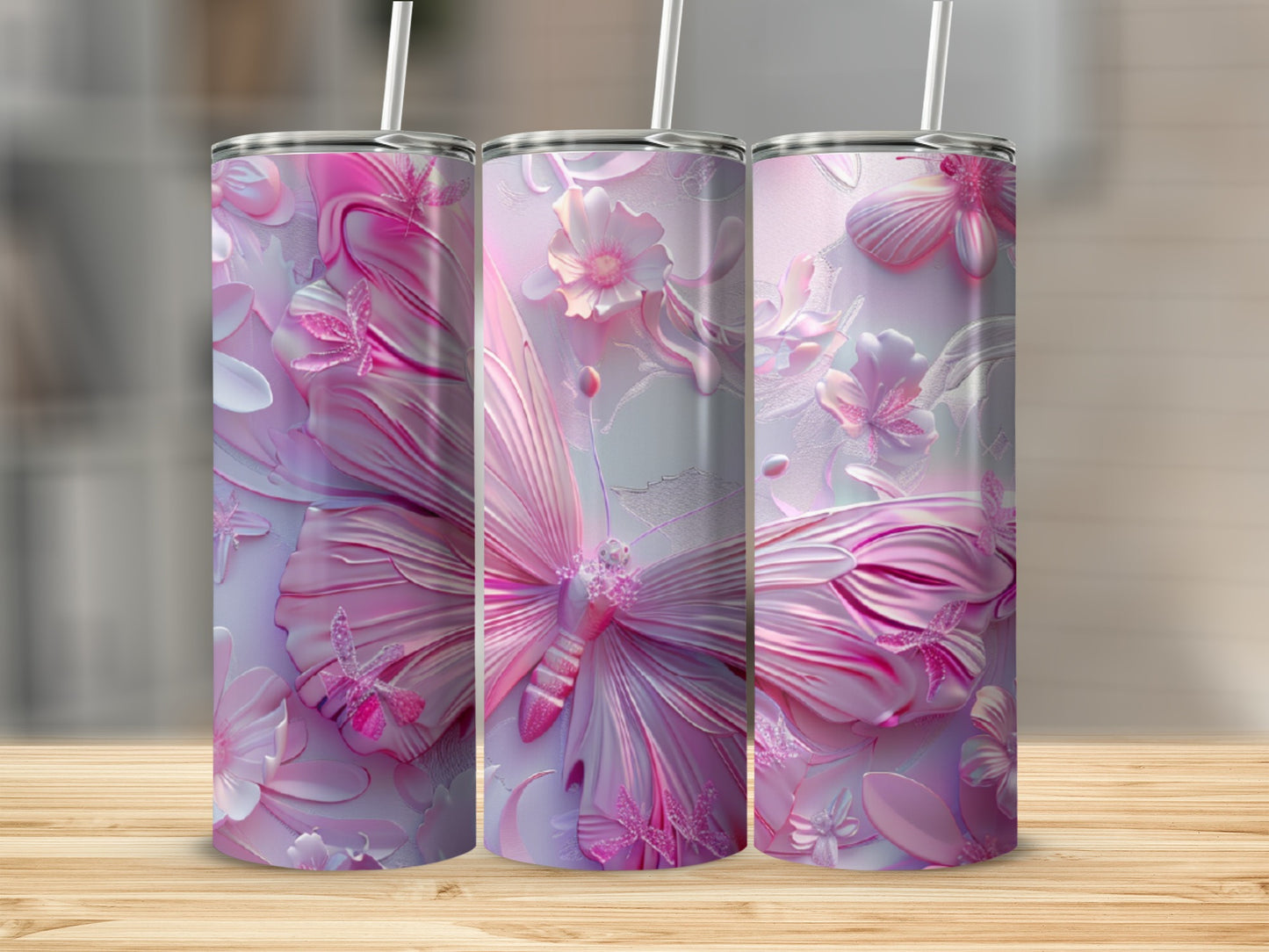 Three pink butterfly tumblers with floral designs on a wooden surface.