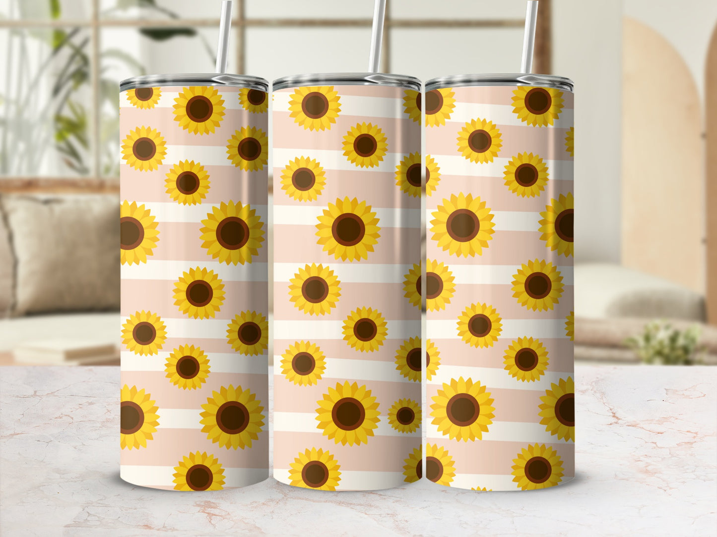 Three tumblers with a sunflower and stripe pattern on a blurred background.