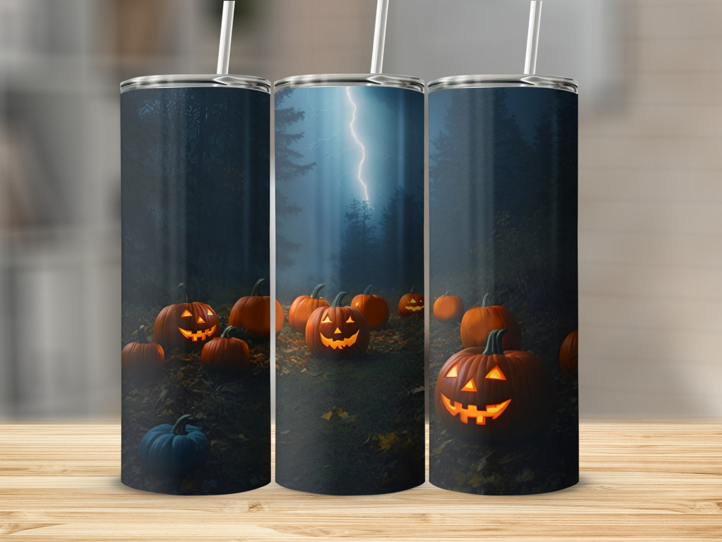 Three tumblers with a Halloween scene of glowing jack-o'-lanterns and lightning.