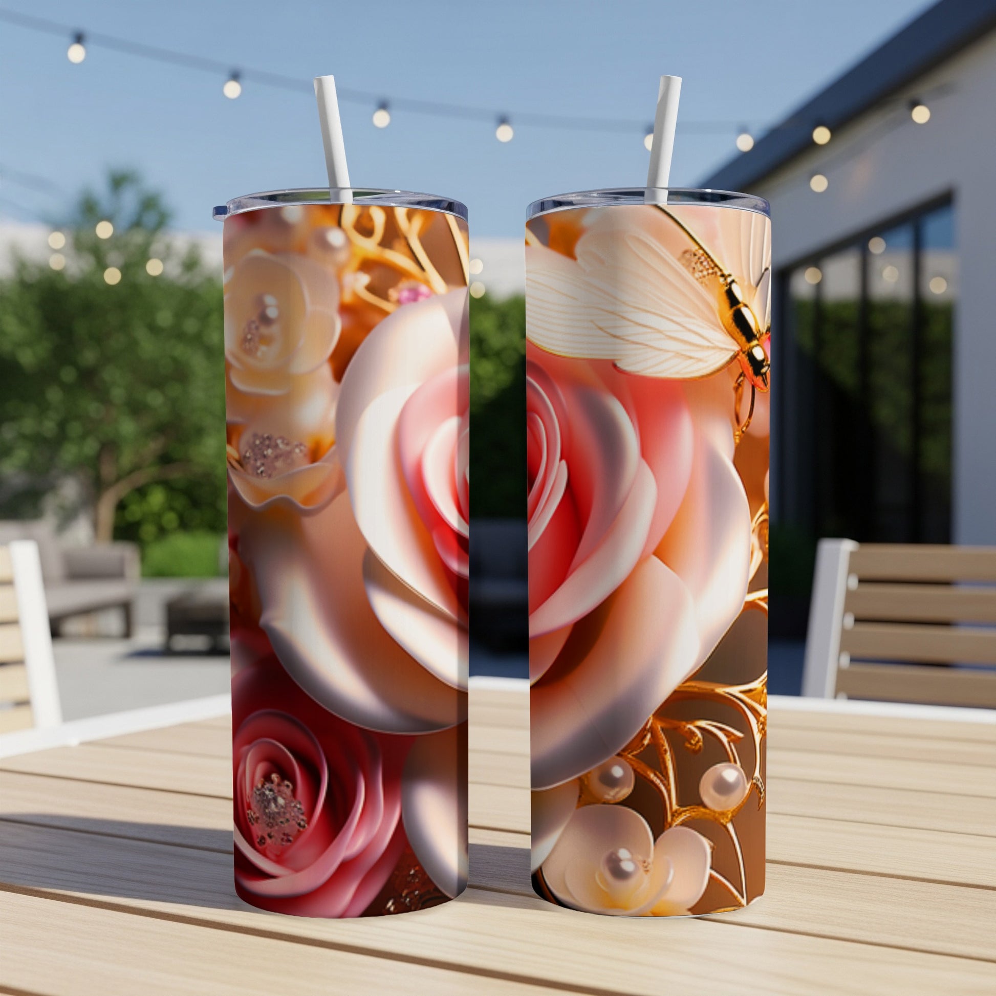 Two tall tumblers with rose and butterfly designs on a wooden table.