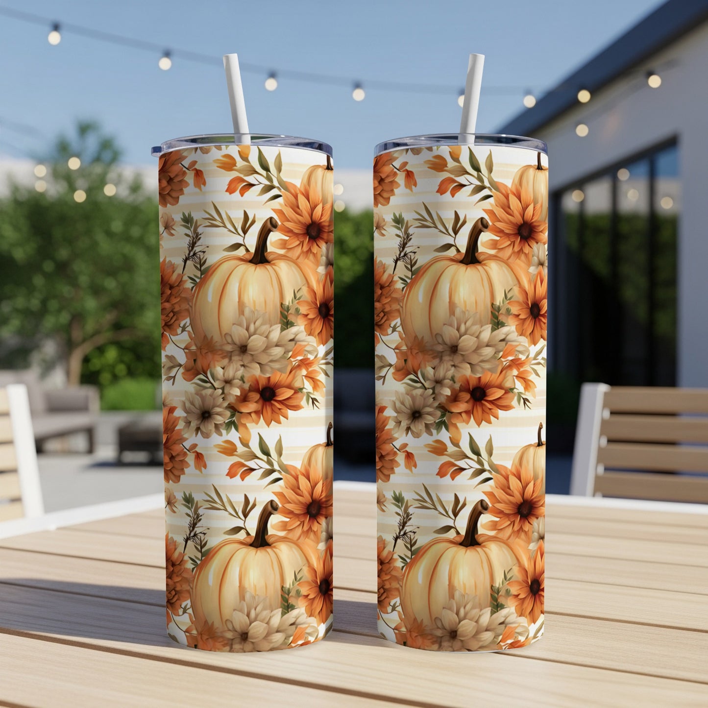 Two tumblers with a fall pumpkin and floral pattern on a wooden table.