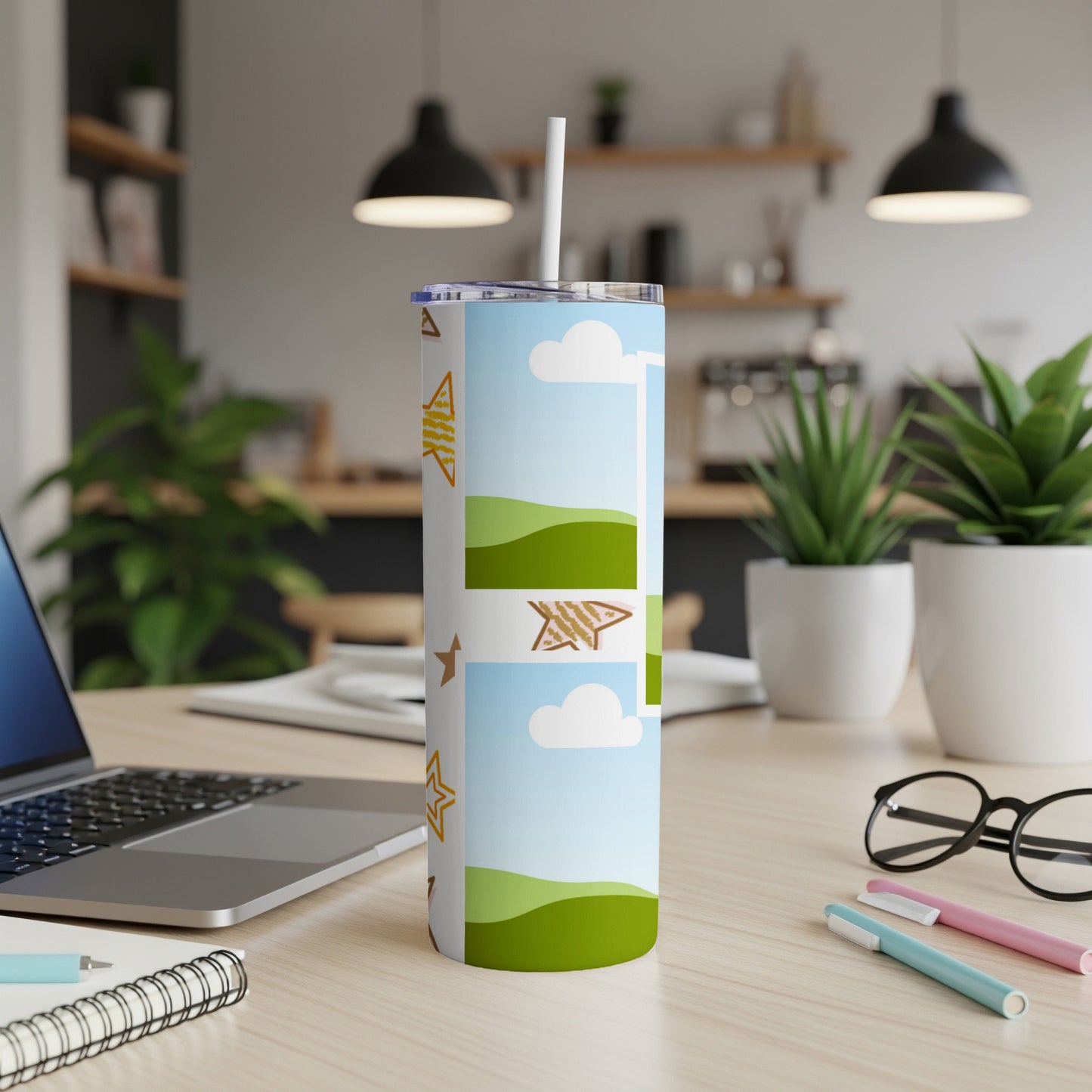 Tumbler with cartoon stars, clouds, and green hills design.