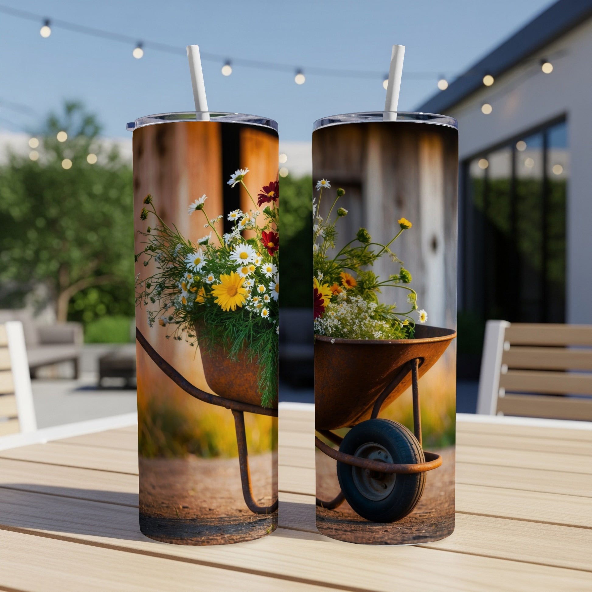 Two tumblers with a wheelbarrow filled with wildflowers on a table.