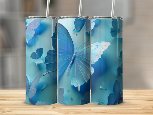 Three blue butterfly tumblers with straws on a wooden surface.