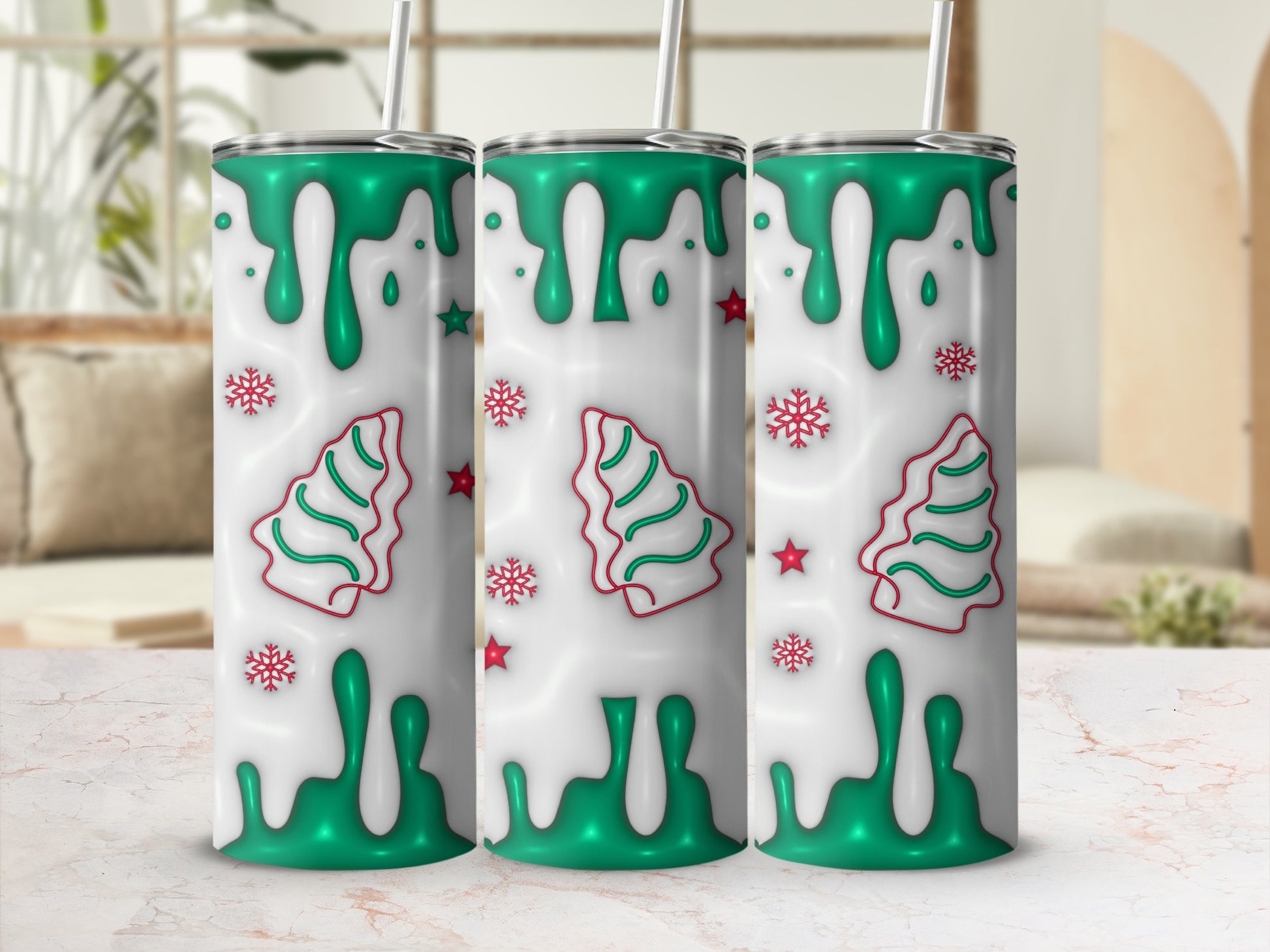 Three holiday-themed tumblers with green trees and snowflakes on white drip.