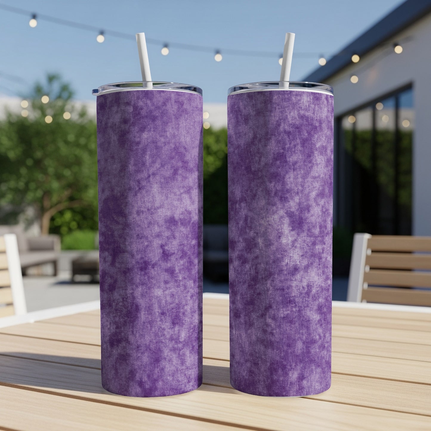 Two purple tumblers with white straws sit on a wooden table outdoors.