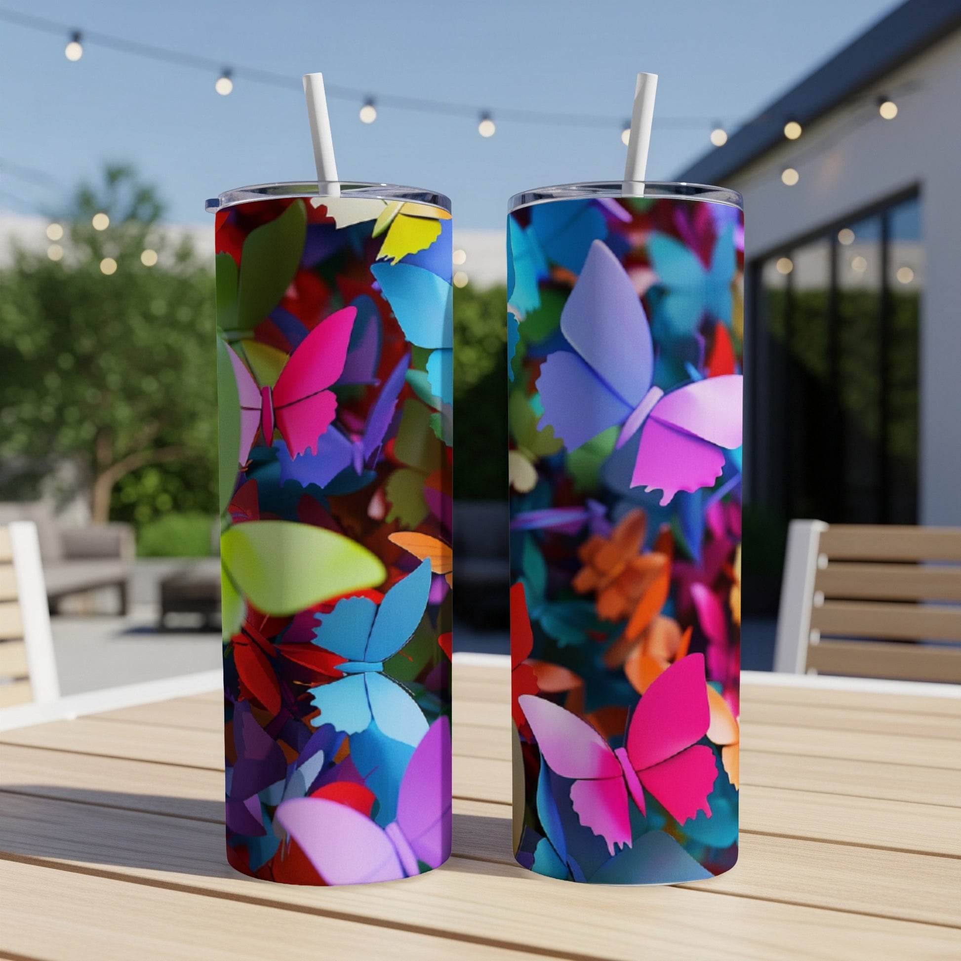 Two tall tumblers with colorful butterfly designs on a table.